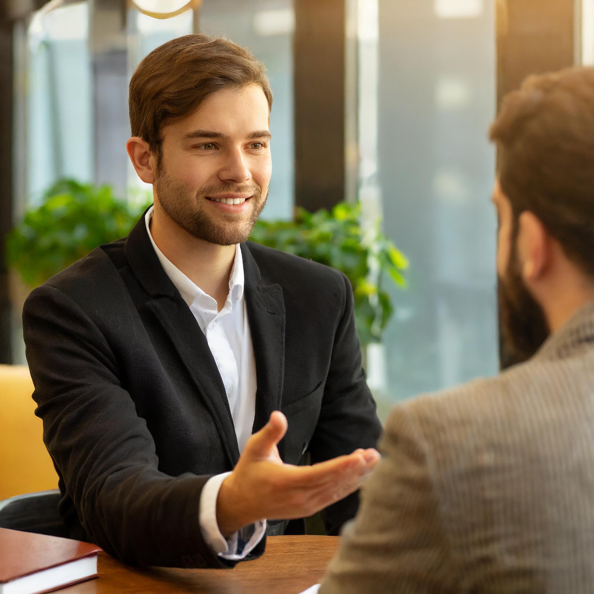 freundliches Gespräch zwischen Steuerberater und Klienten in moderner Umgebung